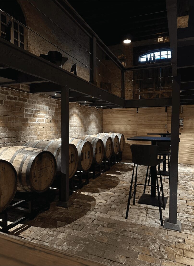 Tasting tables beside the barrels at Ancestral Craft Spirits